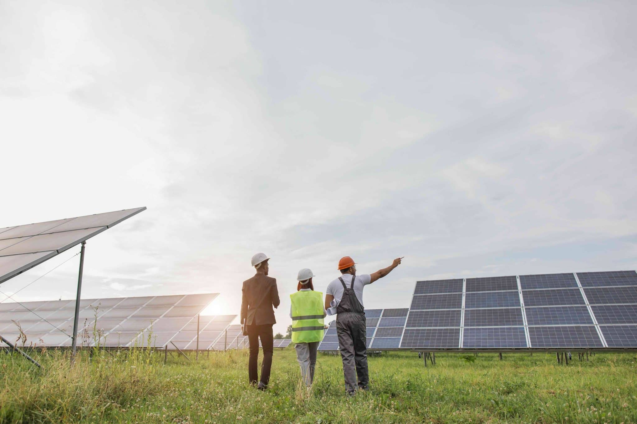 Back view of three workers walking on solar station